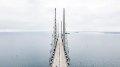 Puente sobre el agua visto desde arriba, símbolo de conexión y continuidad en la planificación sucesoria internacional.