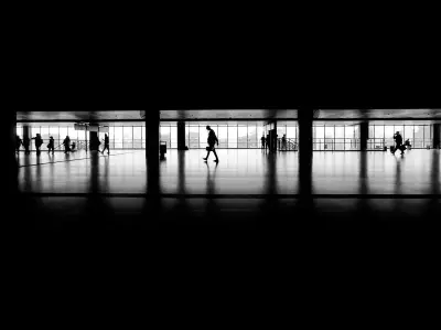 Siluetas de viajeros en una terminal moderna, asociadas a movilidad internacional y residencia fiscal.