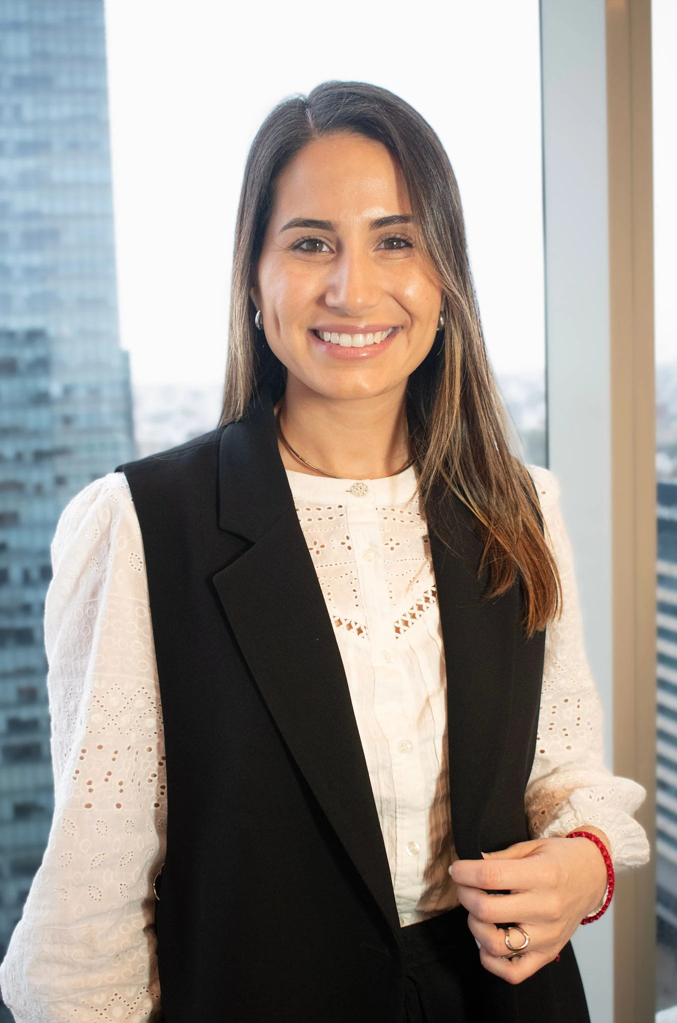 Retrato profesional de Patricia Aires, responsable del departamento contable en InvestaTrust, posando frente a una ventana con vista a un edificio moderno en una ciudad.
