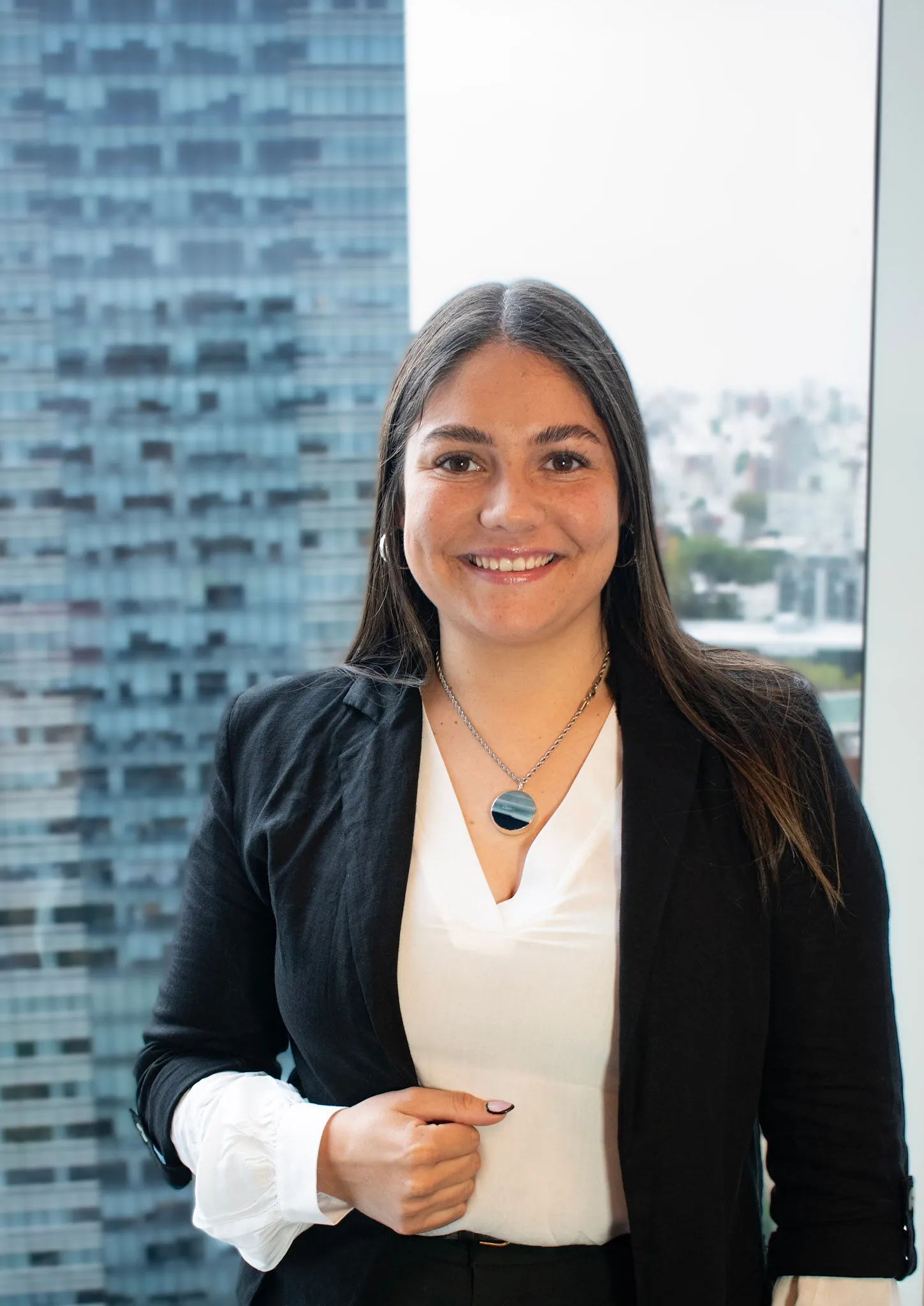 Retrato profesional de Rocío Da Silva, asistente de administración en InvestaTrust, posando frente a una ventana con vista a un edificio moderno.
